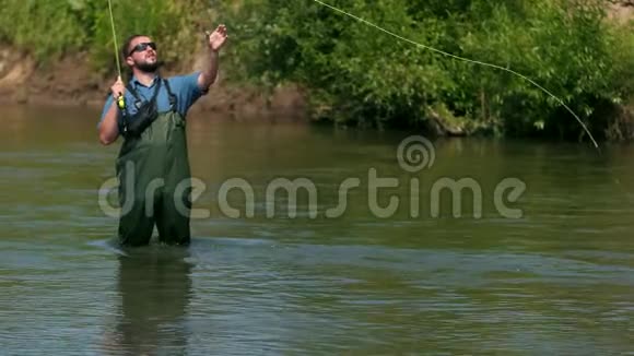 渔夫扔了一个浮子一个人在河上钓鱼站在水里视频的预览图