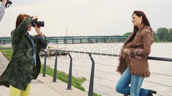 美丽的年轻女子在城市的河边的长廊上摆着石凳视频的预览图