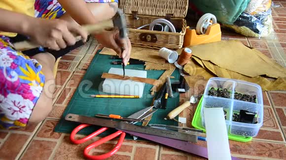 泰国妇女打孔和切割手工制作的袋皮和钥匙环皮革视频的预览图