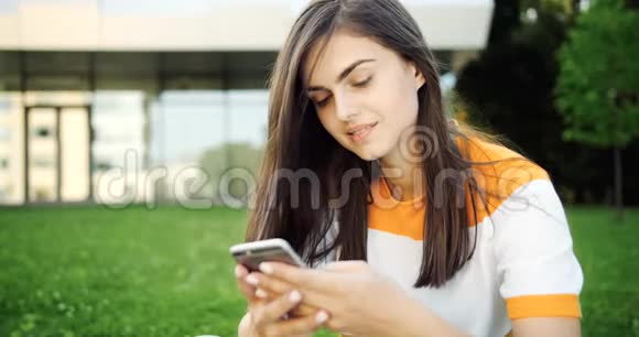微笑的女人在智能手机上发短信视频的预览图