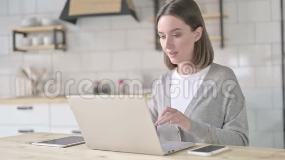 成功女青年在笔记本电脑上庆祝视频的预览图