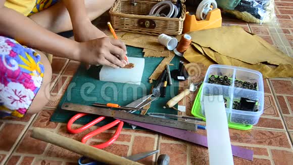 泰国妇女打孔和切割手工制作的袋皮和钥匙环皮革视频的预览图