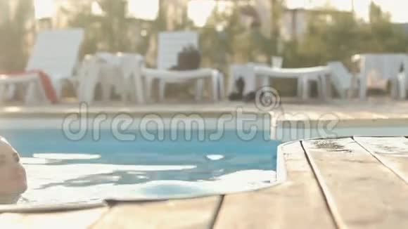 穿着比基尼在游泳池里游泳的美丽的黑发女郎视频的预览图
