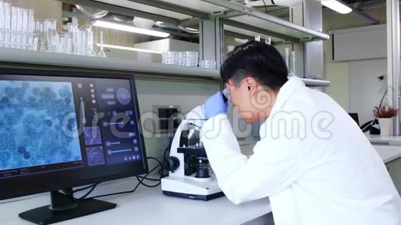 在实验室工作的亚洲科学家博士进行微生物学研究实验室工具显微镜试管设备视频的预览图