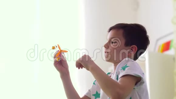 快乐的小男孩在家玩飞机玩具视频的预览图