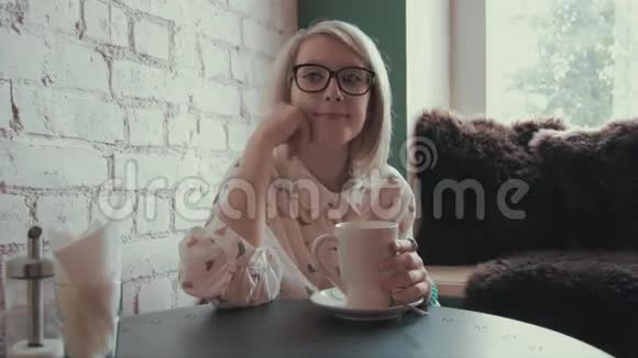 快乐的年轻美女在咖啡馆喝咖啡视频的预览图