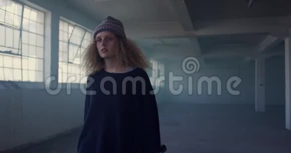 在废弃的仓库里的一个时髦的年轻女人视频的预览图