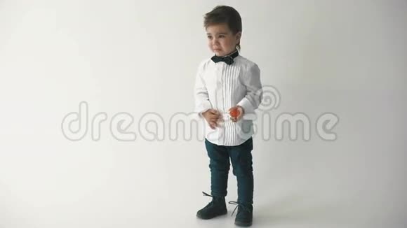 穿着蝴蝶结的小可爱男孩微笑着做着滑稽的脸时髦的休闲孩子视频的预览图