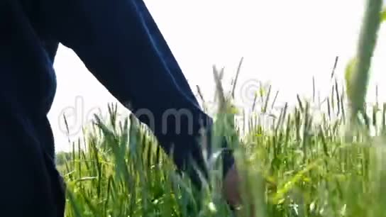 一个穿着制服戴着草帽的年轻人在田野中间的画像视频的预览图