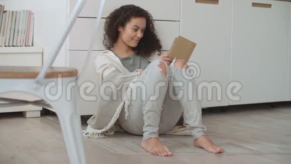 漂亮的年轻女人在舒适的厨房里使用数字平板电脑视频的预览图