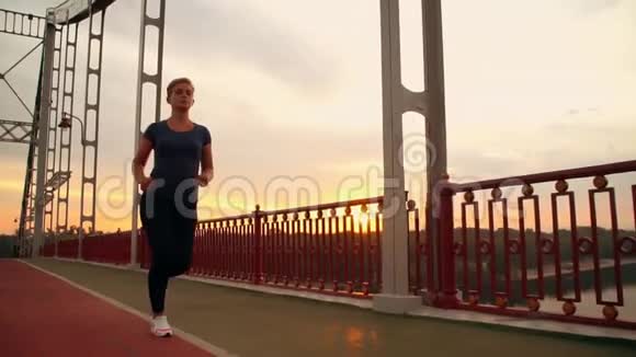 女慢跑者在桥上奔跑视频的预览图