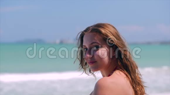 在海滩上近距离欣赏美丽的欧洲女人的肖像看着夏天在海边放松的海浪股票视频的预览图