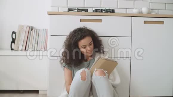 漂亮的年轻女人在舒适的厨房里使用数字平板电脑视频的预览图