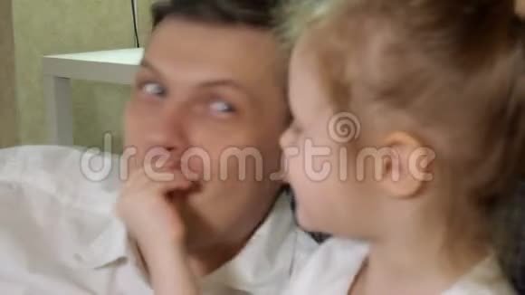 男人和女儿看电视坐在地上吃零食视频的预览图