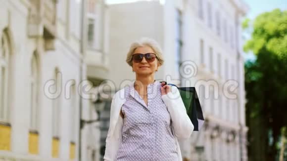 带着购物袋的老妇人在城里散步视频的预览图