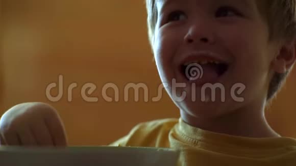厨房里的孩子在桌子旁吃饭宝宝吃快乐的孩子宝贝在厨房吃食物视频的预览图