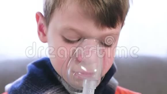 生病的男孩通过吸入器面罩吸入使用雾化器和吸入器进行治疗视频的预览图