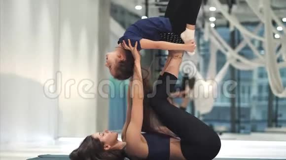 年轻的成年母亲和她的小女儿一起健身视频的预览图