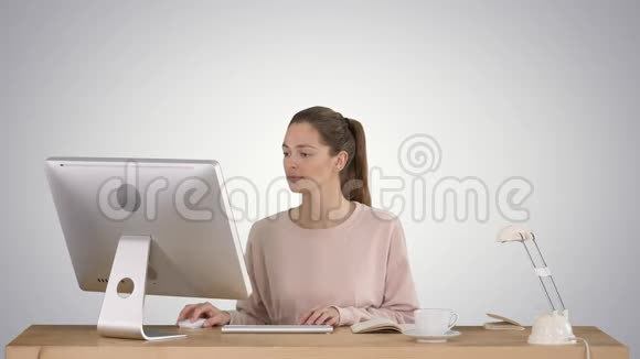 漂亮的女人在梯度背景下的电脑上工作视频的预览图