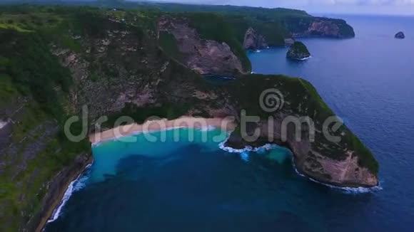 海上和岩石的空中景色从顶部看绿松石水背景夏天从空气中渗出努萨克林金海滩视频的预览图