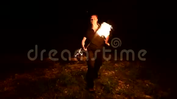 低调年轻的男性长发旋转燃烧火炬户外黑色夜间视频慢动作现代法克尔视频的预览图