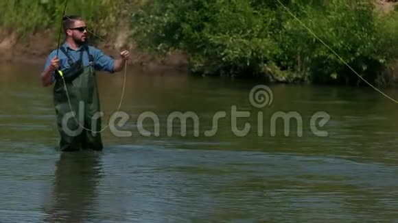 渔夫扔了一个浮子一个人在河上钓鱼站在水里视频的预览图