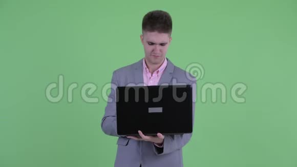 快乐的年轻商人用笔记本电脑思考视频的预览图