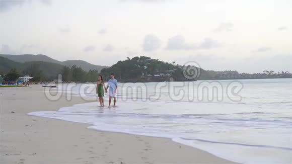 在加勒比海的安提瓜岛一对年轻夫妇在热带海滩上白沙和绿松石海水视频的预览图