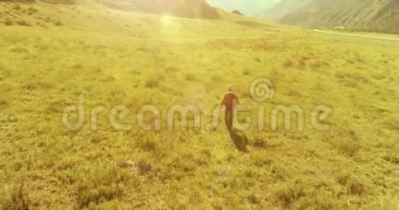 飞行背包徒步旅行游客走过青山野夏日的乡村山谷视频的预览图