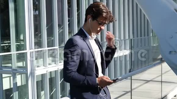 时尚的年轻商务男士带耳机视频的预览图