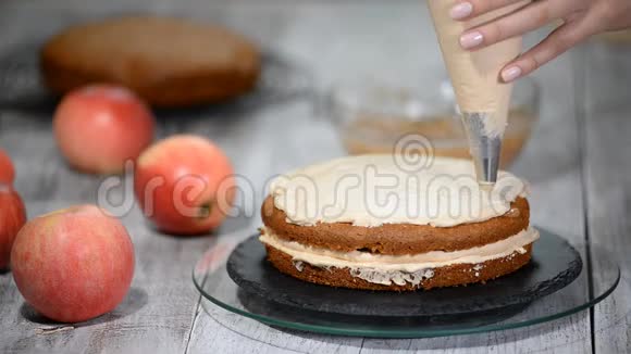 不可辨认的女性糕点厨师在厨房的开胃层蛋糕上挤压奶油视频的预览图