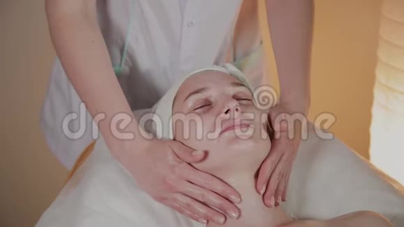 专业美容师为美容办公室的一个年轻女孩做一个复杂的按摩视频的预览图