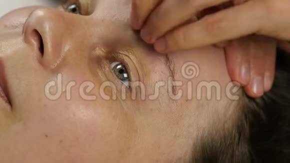 在水疗中心接受头部按摩的女人做面部按摩的女医生视频的预览图