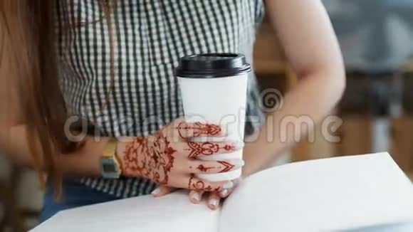 年轻女子啜饮咖啡或茶阅读杂志视频的预览图