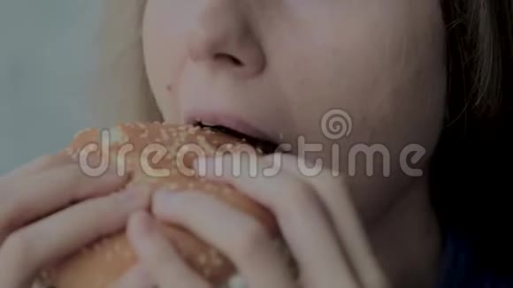 漂亮的女孩吃汉堡快餐店视频的预览图