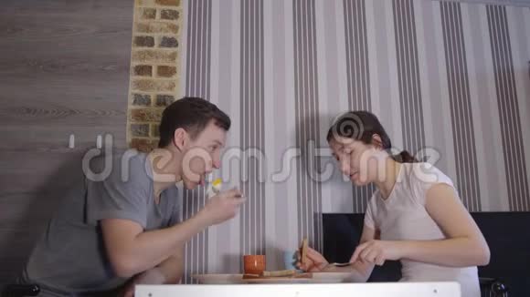 在餐桌上吃饭的男人和女人视频的预览图