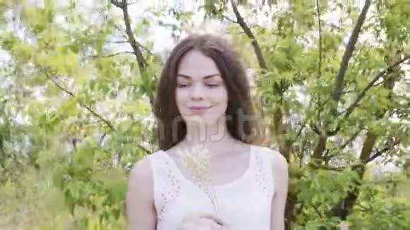 年轻漂亮的女人开着白色的草花视频的预览图