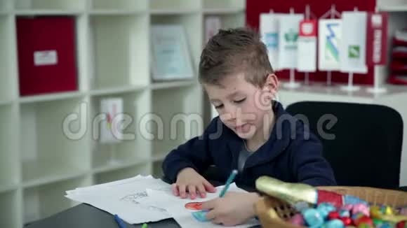 小男孩在幼儿园画画视频的预览图