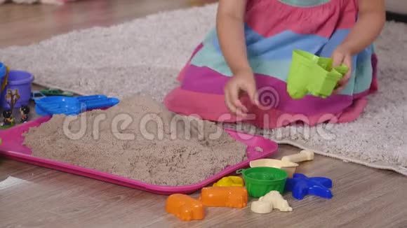 在工作室里玩沙子的可爱金发小女孩视频的预览图
