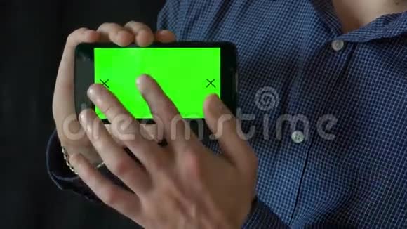特写男性手触摸智能手机绿色屏幕Chroma键快关门跟踪运动垂直的裤子视频的预览图