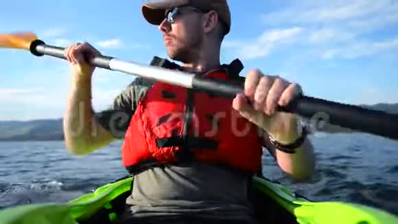 皮艇运动员在湖上划船独木舟中的男子视频的预览图