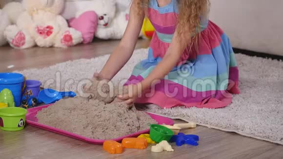 在工作室里玩沙子的可爱金发小女孩视频的预览图
