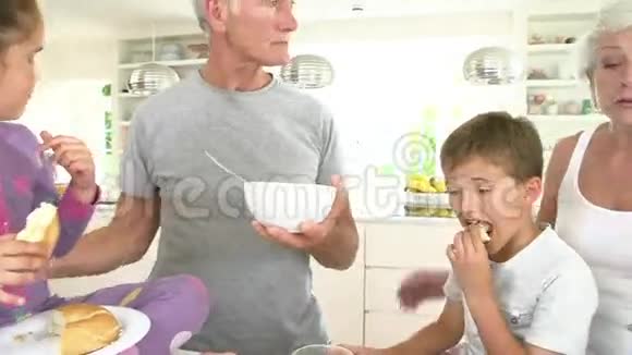 祖父母与孙子女在厨房吃早餐视频的预览图