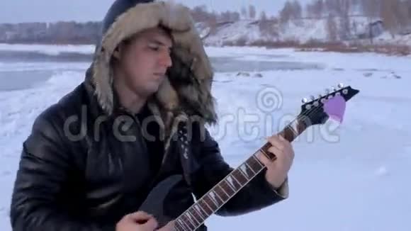 冬天的一个年轻人弹吉他视频的预览图