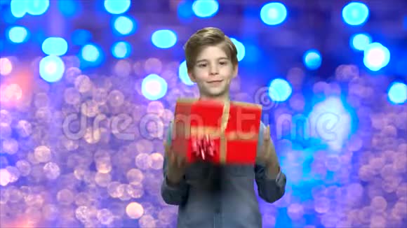 有圣诞背景礼盒的男孩视频的预览图