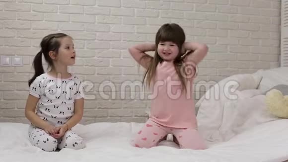 两个可爱的孩子们在卧室里玩视频的预览图