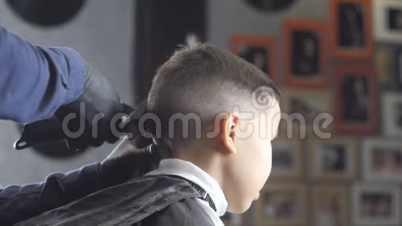 戴着黑色手套的理发师在一个亚洲男孩60英尺长的头发上剃掉头发视频的预览图
