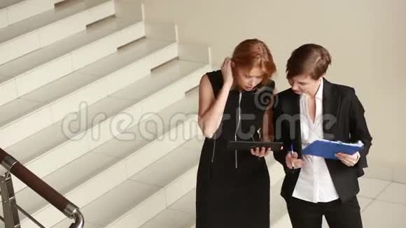 两个女商人在讨论合同绕着办公室转视频的预览图