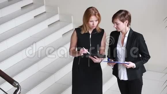 两个女商人在讨论合同绕着办公室转视频的预览图