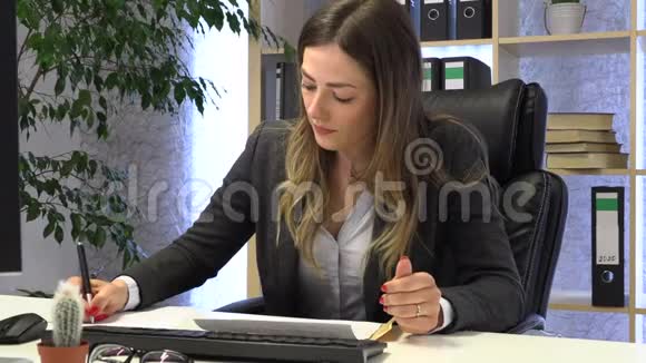 经理在电脑上写字并检查表格上的文档视频的预览图